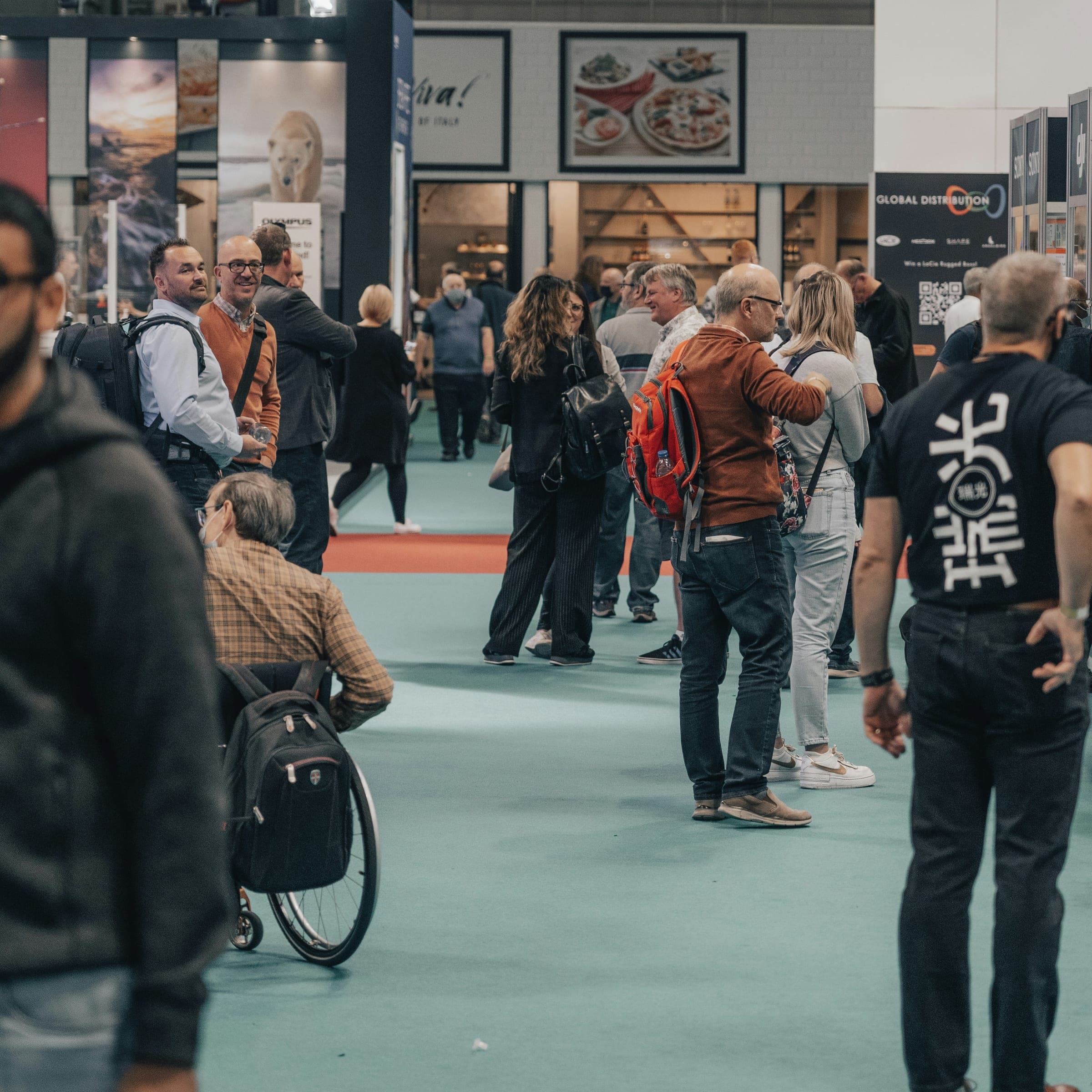 Attendees browsing exhibitor booths on a busy show floor