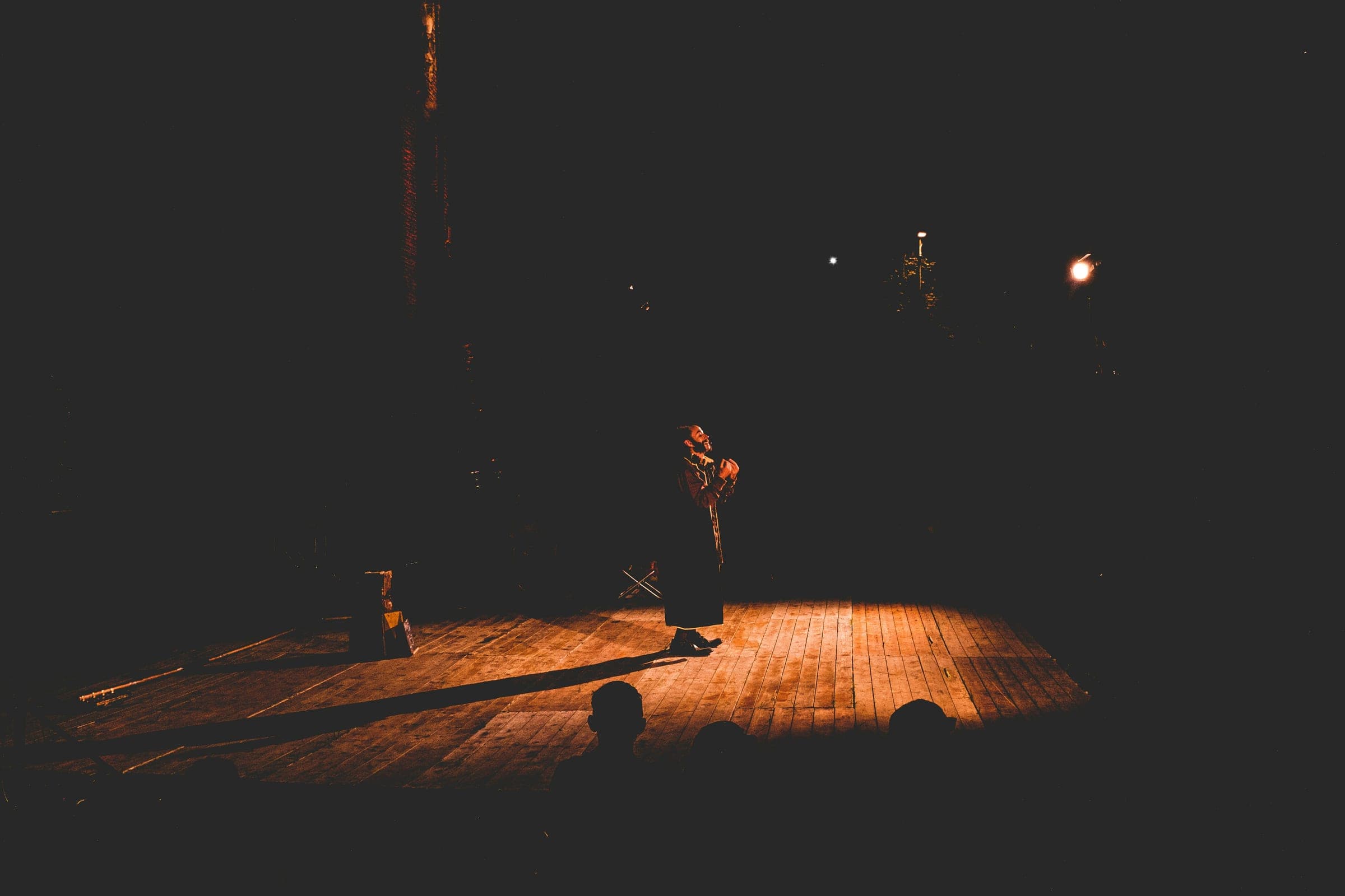 A single performer under a spotlight on an empty stage