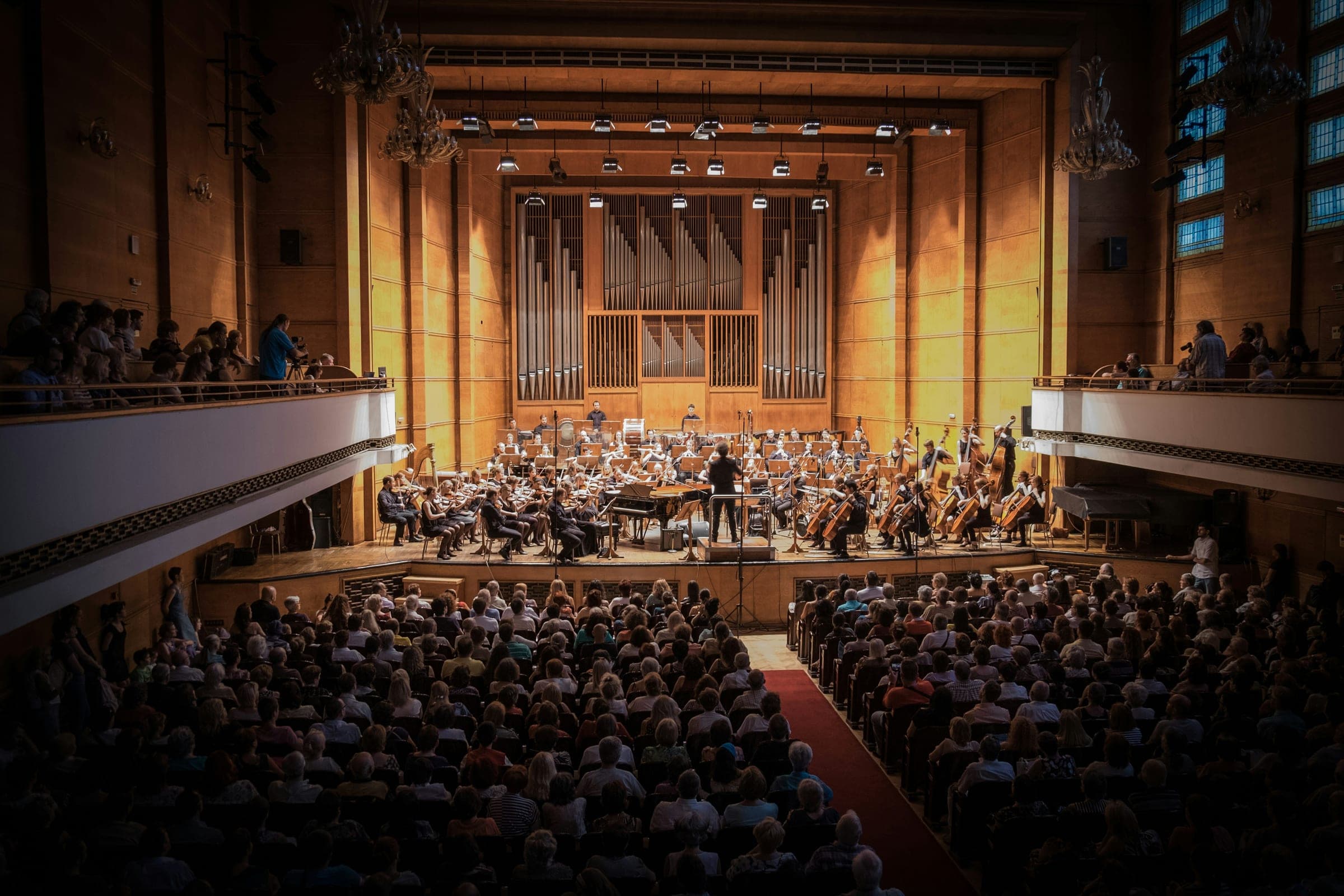 A full orchestral concert hall, audience and performers alike